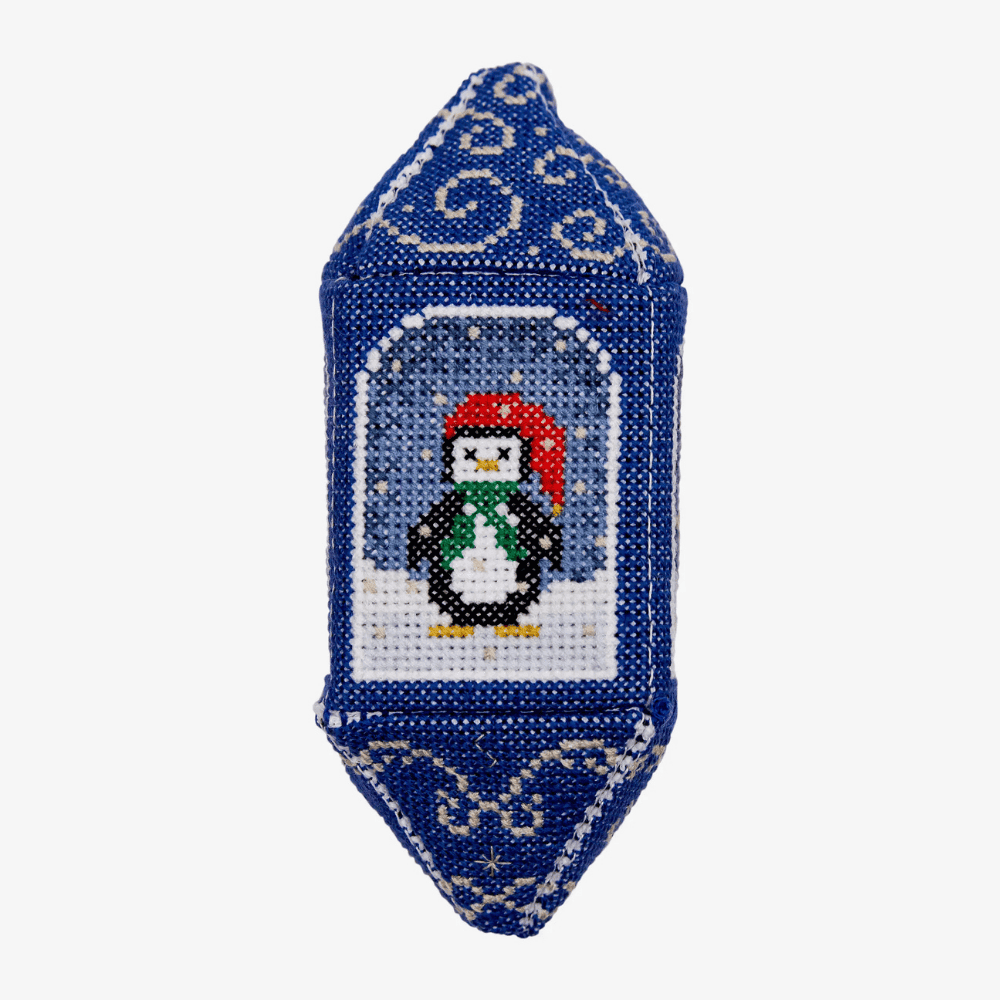 Decorative ornament with a penguin design on a blue background