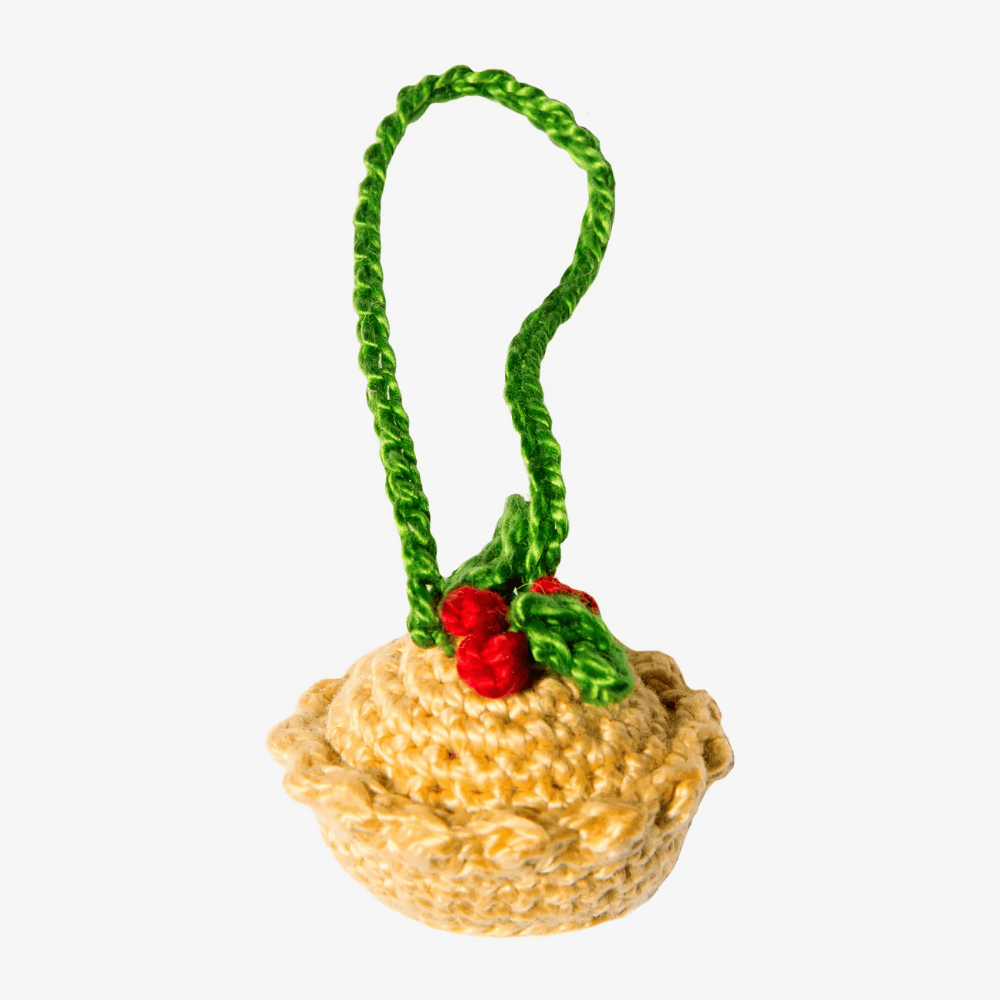 Knitted Christmas pudding ornament with a green ribbon on a white background